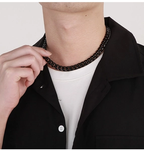 Close-up of black stainless steel Cuban link chain necklace worn on a male model