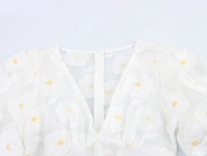 Close-up of white mesh dress with yellow floral embroidery and invisible zipper detail