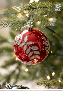 Dettaglio di una pallina di Natale rossa con motivi a foglia d'argento glitterati