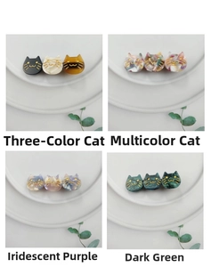 Detail showing acetate cat-shaped hair clips in four colorful patterns on a white plate