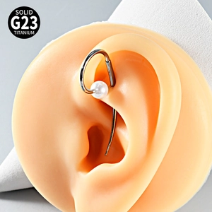 G23 titanium ear piercing with white pearl shown on a realistic silicone ear model