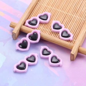 Close-up of pink heart-shaped resin sunglasses miniatures for DIY craft accessories