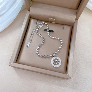 Detail of titanium steel beaded bracelet with sparkling crystal double heart pendant