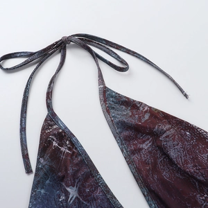 Gros plan sur le nœud licou et l'imprimé marbré de la robe moulante dos nu