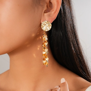 Golden hammer-textured round earrings with cascading multi-layer sequins on model