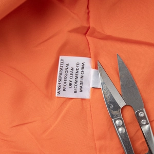 Detailed view of the wash care label and fabric lining on the orange cotton linen set