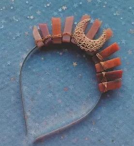 Detail of handmade gold wire-wrapped crown with orange crystals and crescent moon