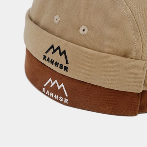 Détail de la casquette rétro docker avec broderie montagne et texture en sergé de coton