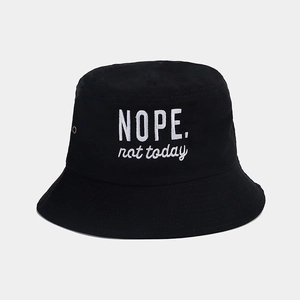 Detail of white NOPE embroidery on black cotton bucket hat with vent eyelets