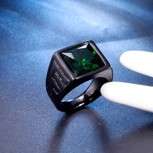 Macro shot of men's vintage black ring with square green gemstone and textured band