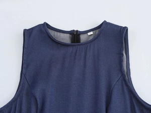 Détail d'une robe en jean bleu sans manches avec fermeture éclair noire et étiquette