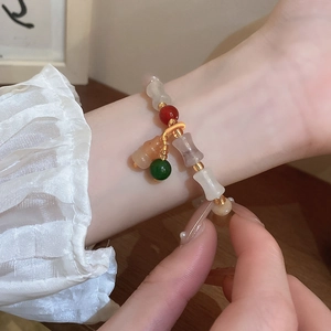 Detailed shot of beaded bracelet with bamboo joints and colorful gourd charms on wrist