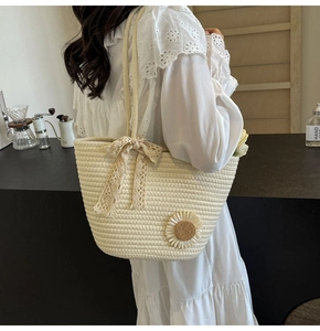 Detail of hand-woven tote bag with sunflower applique and delicate lace bow ribbon