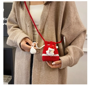 Detailed view of a handmade red crochet Christmas bag with Santa motif on a model