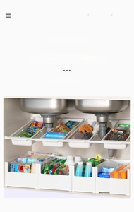 Adjustable white plastic sink organizer with retractable hooks for cabinet storage space