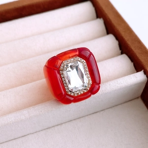 Macro detail of red vintage resin ring with large white crystal in a jewelry box
