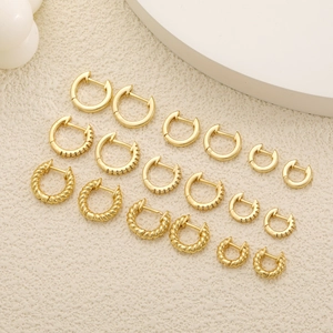 Detailansicht goldener Creolen im Set mit minimalistischen, gedrehten und Zirkonia-Designs