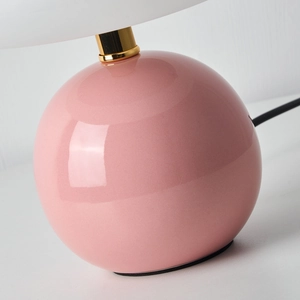 Pink ceramic mushroom desk lamp with a spherical base and white shade for room ambiance