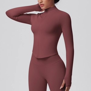 Detail of dark brick red yoga jacket showing thumbhole cuffs and ribbed fabric texture