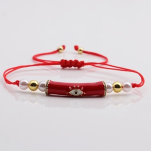 Red braided rope bracelet with enamel evil eye charm, gold beads, and white pearls