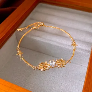 Elegant gold iris flower bracelet with oval zircon inlay and butterfly charm detail