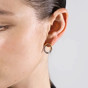 Minimalist 18K gold and silver two-tone hoop earrings with wrinkled texture on model