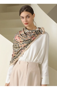Detail of silk-like scarf with paisley floral pattern draped over a white shirt