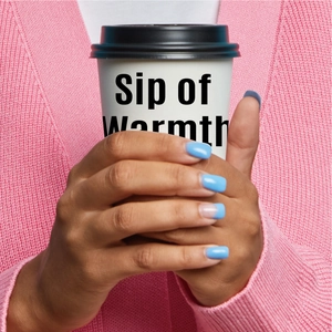 Close-up of pink knit cardigan texture featuring a hand holding a white coffee cup