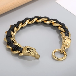 Close-up of golden skull charms and black braided leather strap on a punk bracelet