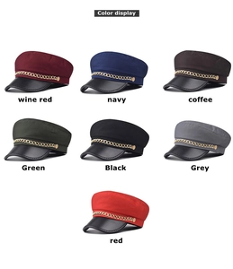Close-up of retro newsboy hats with fabric crowns, leather brims and gold chain details
