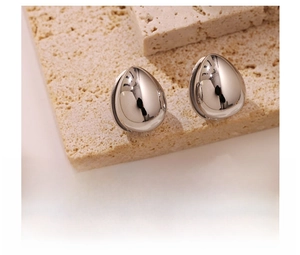 Macro shot of silver teardrop stud earrings in titanium steel with a polished finish