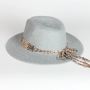 Detailed texture of light blue straw sun hat with bohemian fringe and woven band