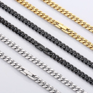 Close-up of gold, black, and silver Cuban link chains with secure box clasp detail