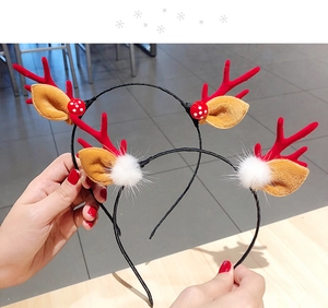 Detail of Christmas reindeer antler headbands with red fabric antlers and plush white pom-poms