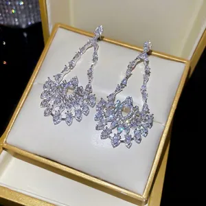 Elegant silver leaf drop earrings with marquise cubic zirconia on a jewelry box