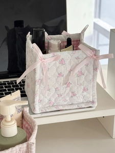 Quilted floral fabric storage basket with pink bow ties for desk organization