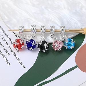 Macro shot of 5 multifaceted crystal ball charms in silver cages for jewelry making