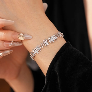 Silver bracelet with square zircon inlays worn by model on black background clothing