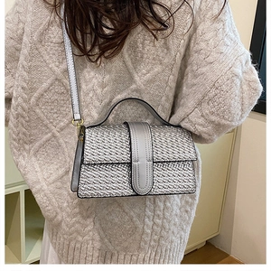 Silver woven texture crossbody bag shown styled on a shoulder with a cream knit sweater