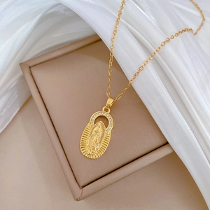 Macro detail of gold-plated Our Lady of Guadalupe pendant with small sparkling zircon crystals