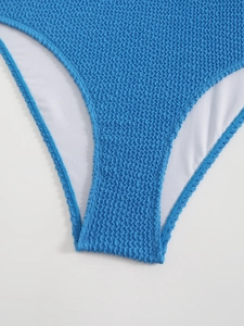 Détail de la texture en tissu seersucker bleu vif sur un maillot de bain dos nu