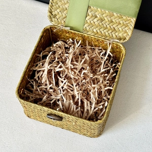Top view of natural woven straw gift box with green satin lining and wood buckle