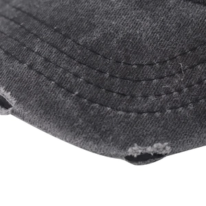 Detailed macro view of washed gray denim baseball cap brim with distressed rip effects