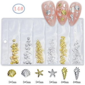 Detailed macro view of 14# gold and silver seashell nail art studs in a 6-grid bag