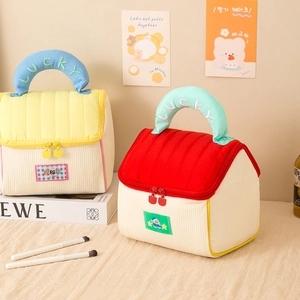 Cute house-shaped corduroy makeup bag with embroidery and top handle in home setting