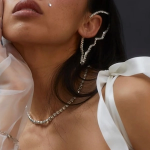 Close-up of sparkling silver butterfly wing ear cuff and matching crystal necklace