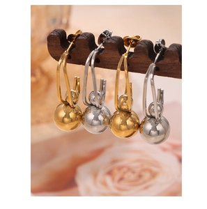 Close-up of geometric titanium steel hoop earrings with sphere charms in gold and silver