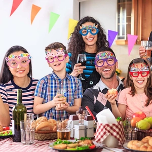 Family wearing colorful paper Happy Birthday glasses at a decorated party table