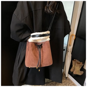 Chic brown suede bucket bag with white faux fur trim and drawstring closure detail