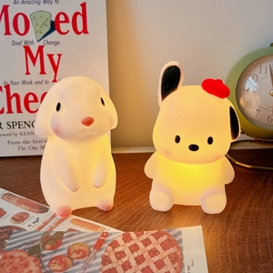 Close-up of cute rabbit and dog silicone night lights emitting warm yellow light